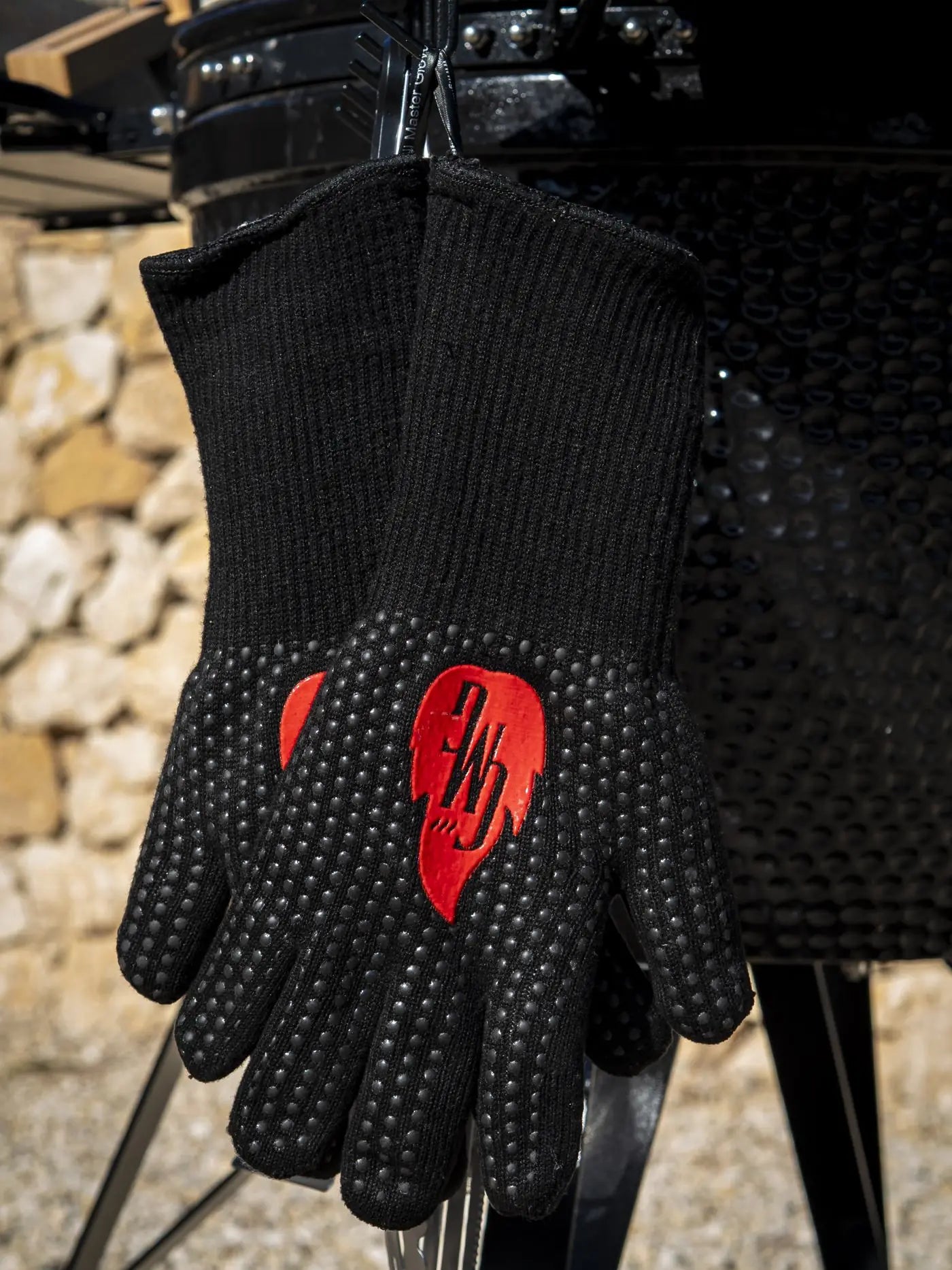 Grill Master Gloves houdt een gloeiend stuk houtskool vast