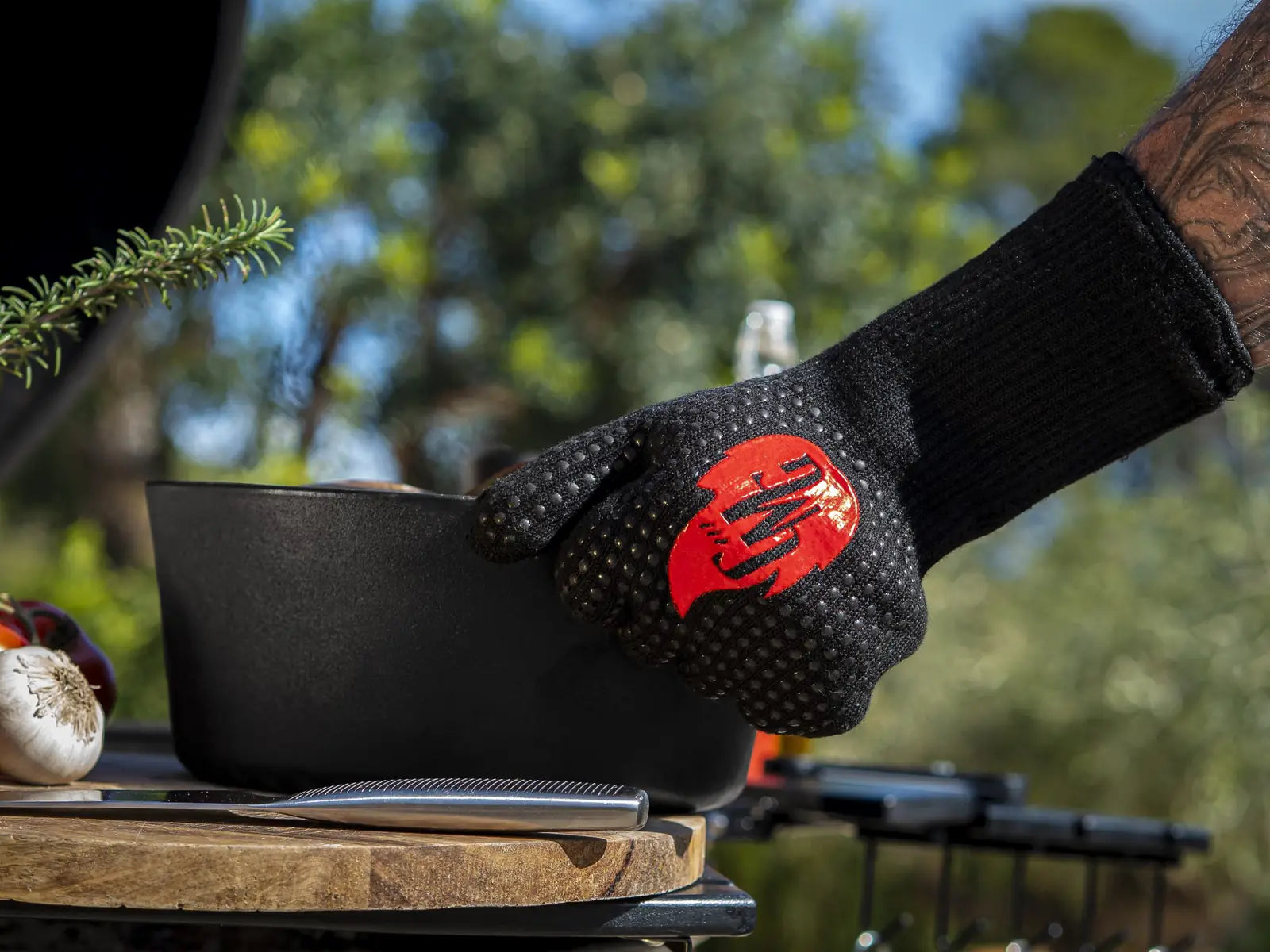 Grill Master Gloves tilt een gietijzeren pan van de kamado